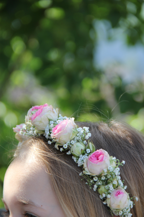 Mädchen mit Haarreif geschmückt mit kleinen Rosenblüten und Schleierkraut